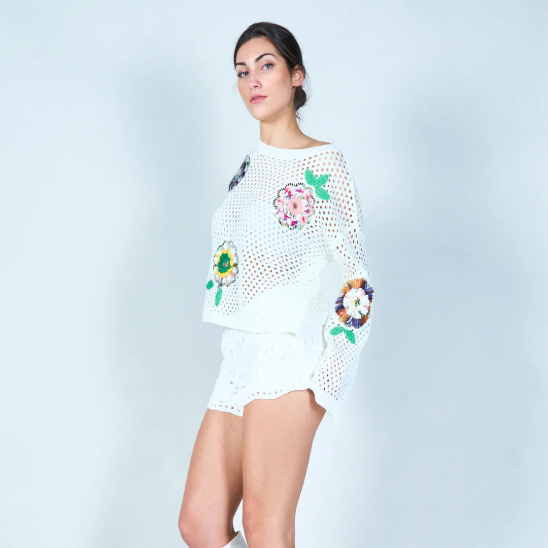Open-knit sweater with colorful floral appliqués wholesale